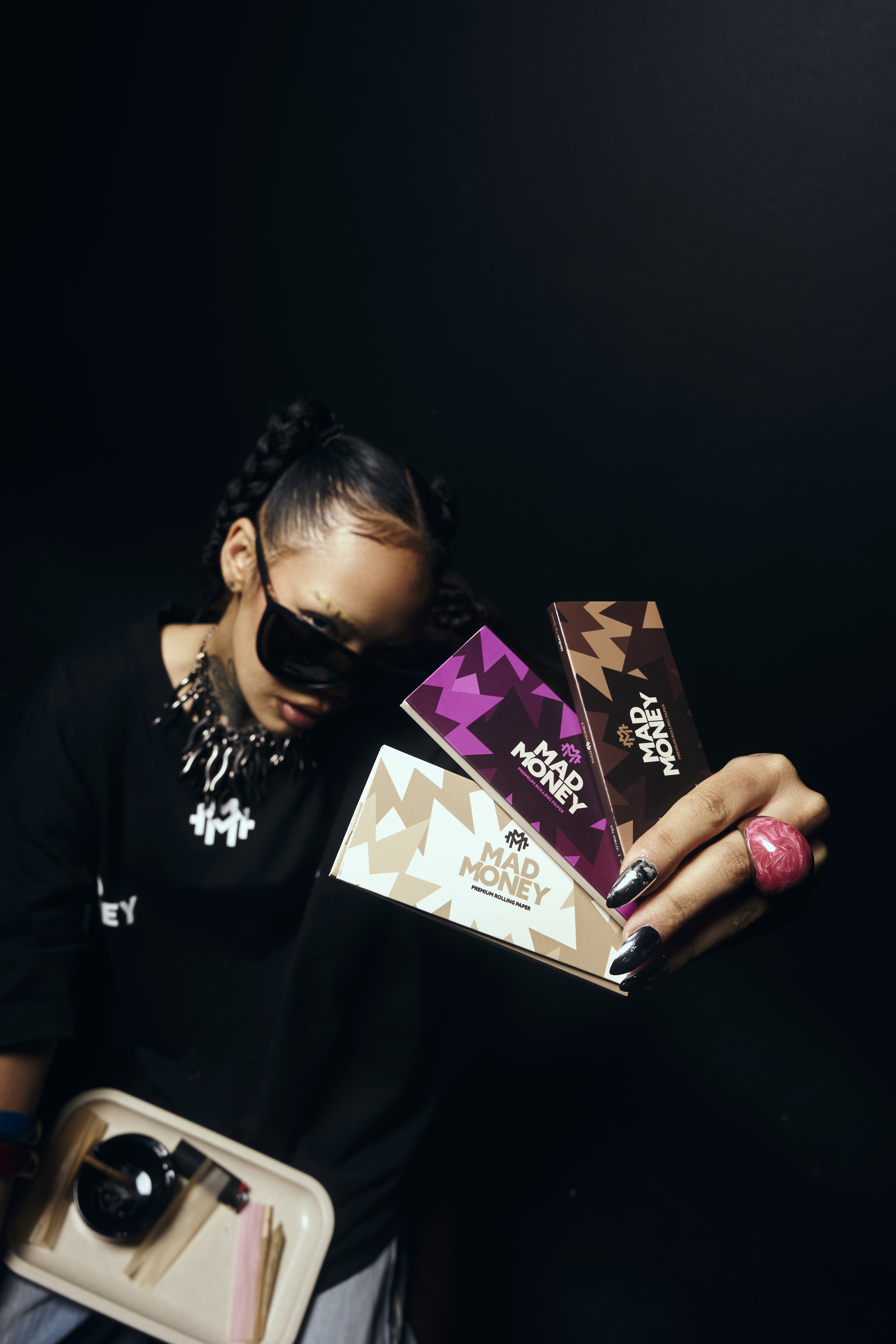 MadMoney hand holding rolling paper packs